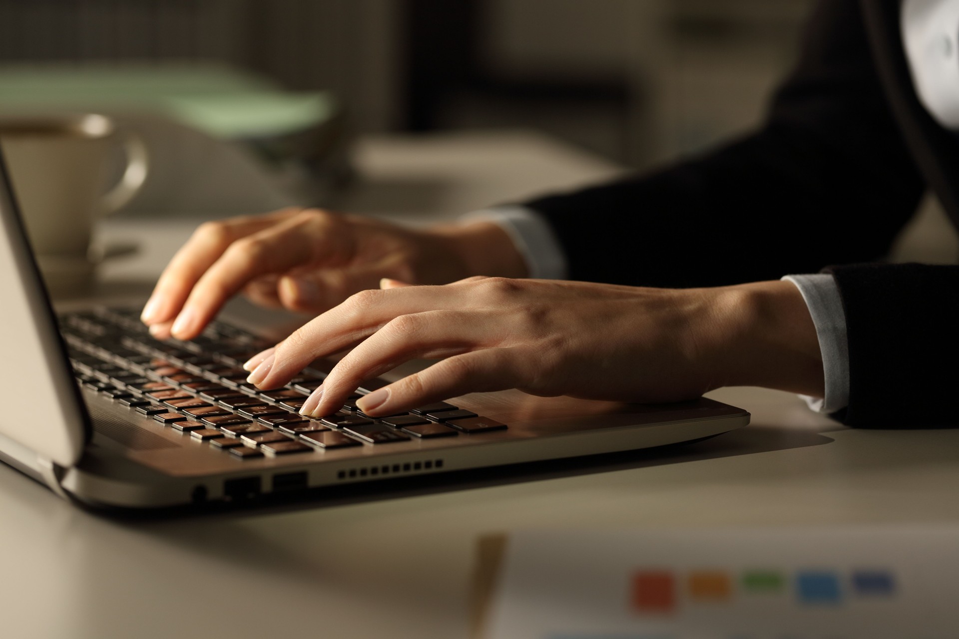 Business woman hands typing on laptop at night